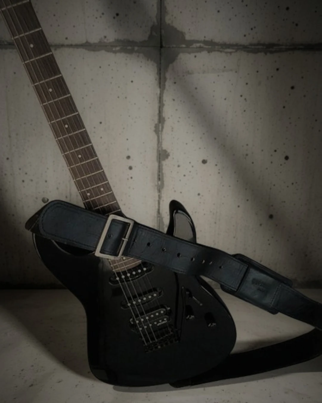 ACID · GAIA STRAPS en piel de vacuno negro sobre guitarra eléctrica negra
